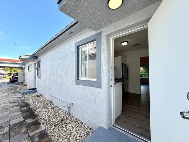 a view of a hallway with wooden floor and windows