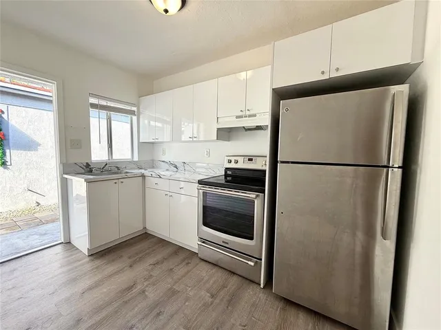 a kitchen with a refrigerator sink and cabinets