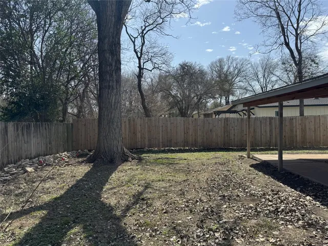 a backyard with wooden fence and trees