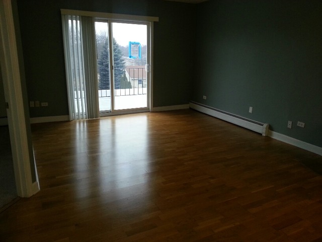 1000 South Lorraine Road, Unit 410 Wheaton, IL 60189 - Photo 3 of 12 a view of an empty room with wooden floor and a window