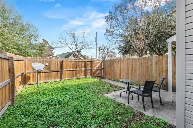 a view of backyard with deck and wooden fence