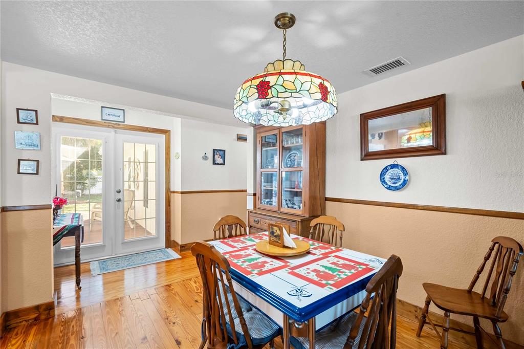 1109 Commodore Street Clearwater, FL 33755 - Photo 13 of 42 a view of a dining room with furniture wooden floor and chandelier