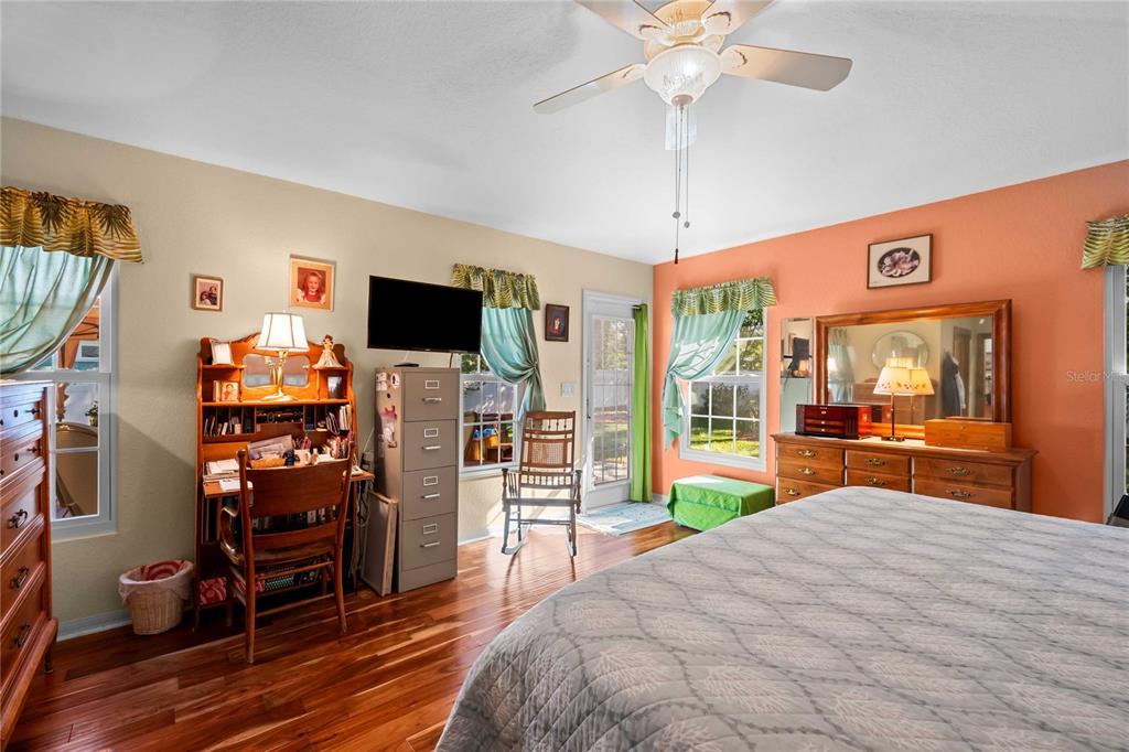 1109 Commodore Street Clearwater, FL 33755 - Photo 21 of 42 a bedroom with a bed and a flat tv screen on dresser