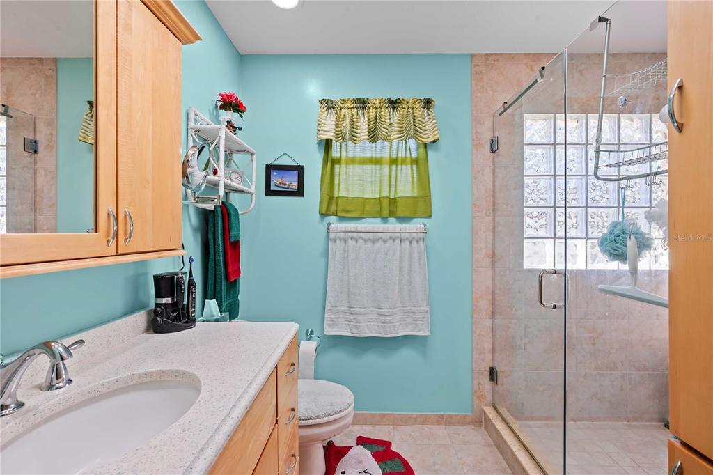 1109 Commodore Street Clearwater, FL 33755 - Photo 22 of 42 a bathroom with a sink vanity granite toilet and shower