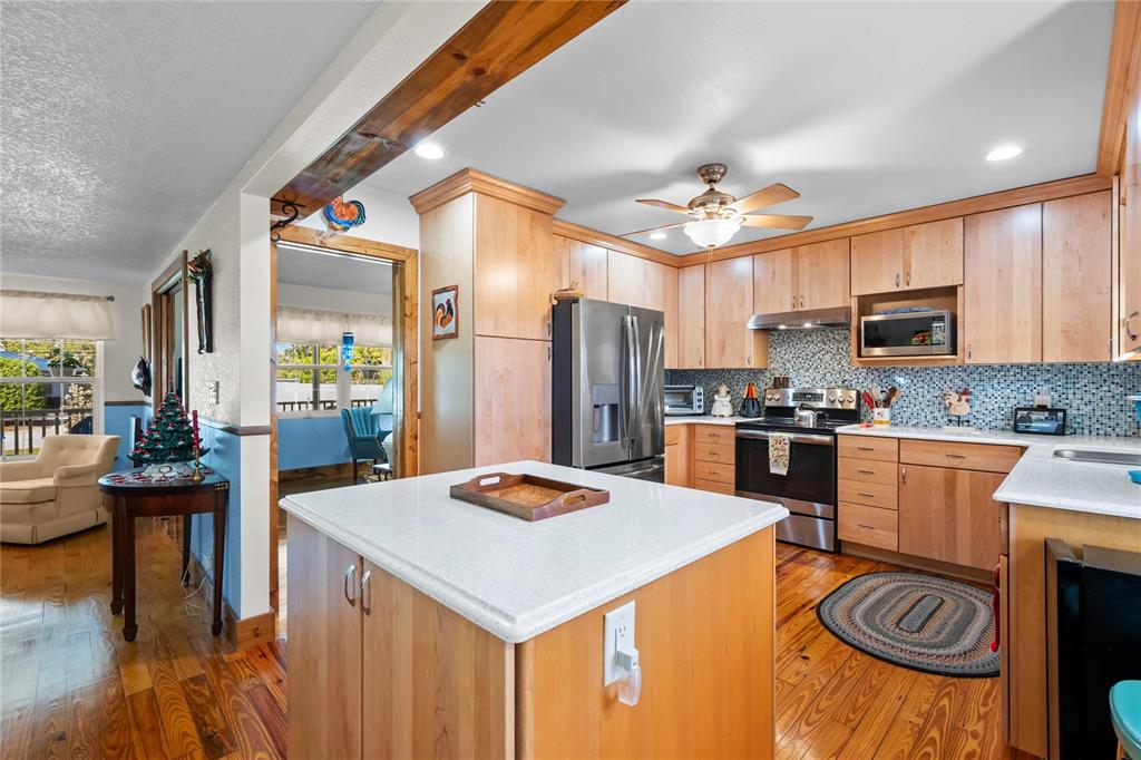 1109 Commodore Street Clearwater, FL 33755 - Photo 7 of 42 a kitchen with a refrigerator a stove a sink dishwasher with a dining table and chairs with wooden floor