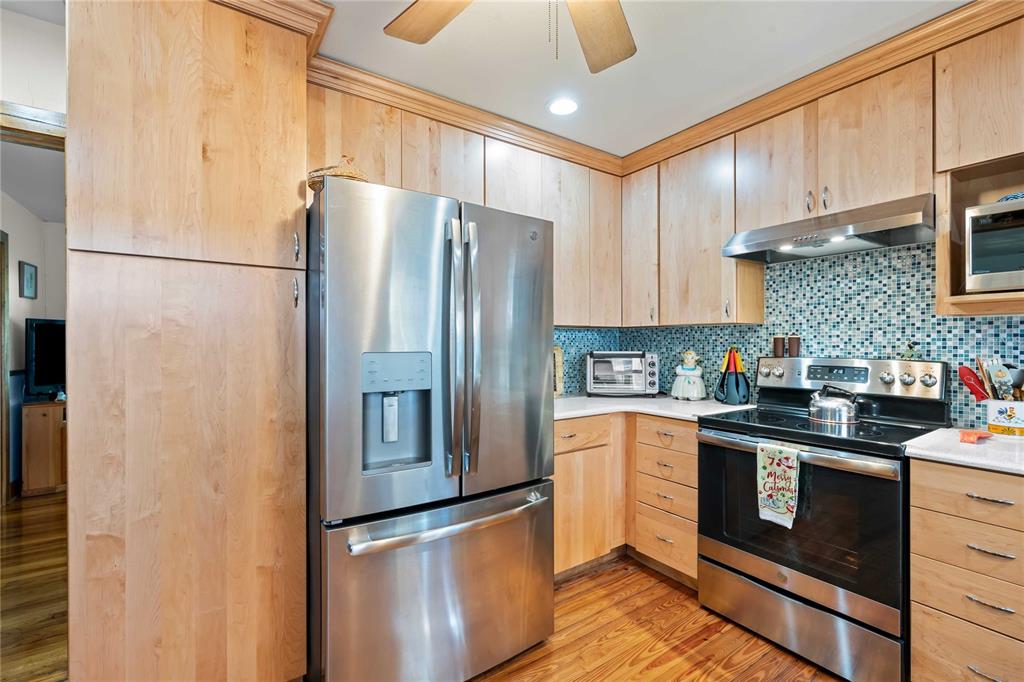 1109 Commodore Street Clearwater, FL 33755 - Photo 9 of 42 a kitchen with stainless steel appliances granite countertop a refrigerator a stove a sink and a microwave