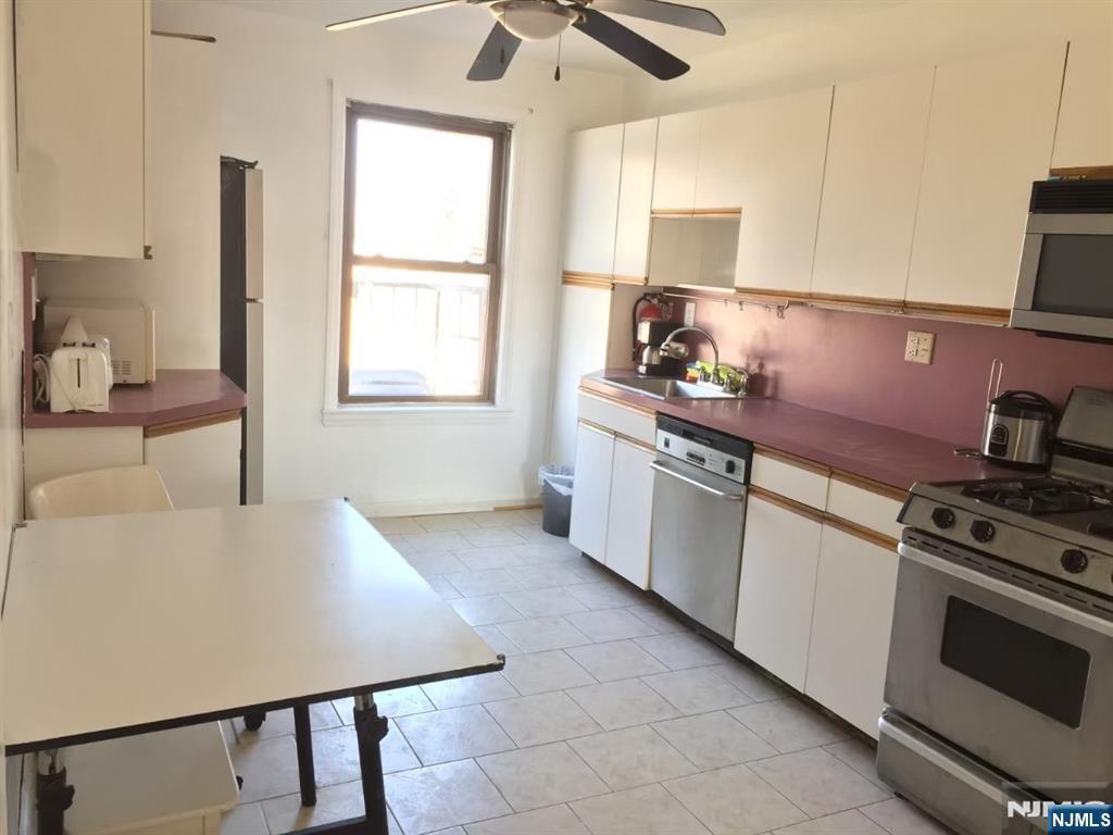 418 Main Street, Unit D6 Fort Lee, NJ 07024 - Photo 2 of 7 a kitchen with stainless steel appliances granite countertop a stove a sink and a refrigerator