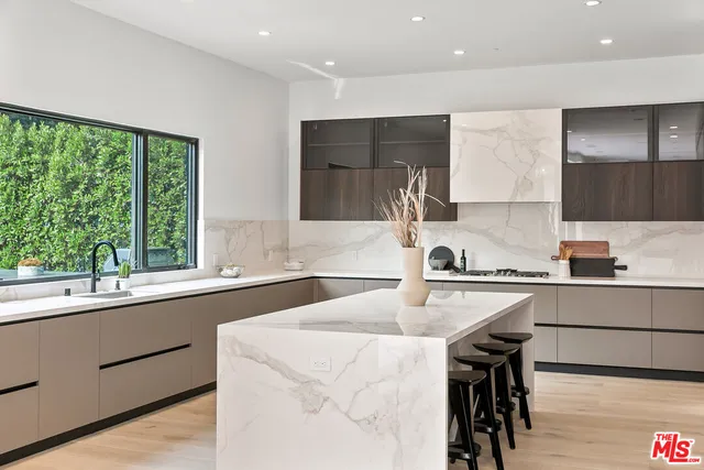 a kitchen with a sink a stove a refrigerator and a stove top oven