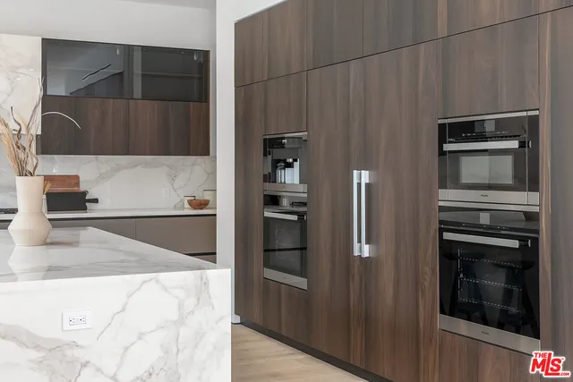 a kitchen with stainless steel appliances kitchen island granite countertop a refrigerator and a stove