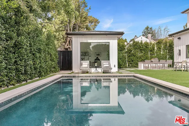 a view of a house with backyard patio and swimming pool