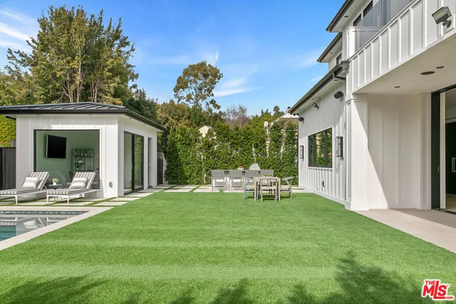 a view of backyard with swimming pool and outdoor seating