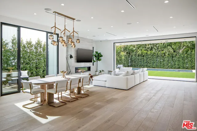 a living room with furniture a flat screen tv and a floor to ceiling window
