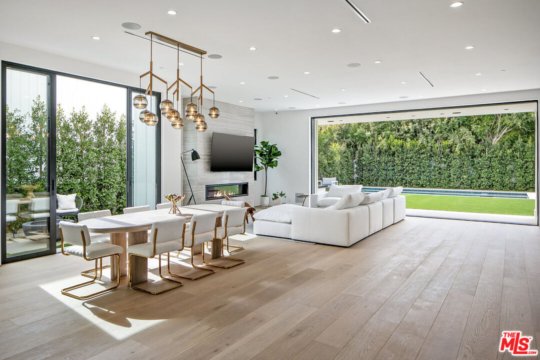 211 Veteran Avenue Los Angeles, CA 90024 - Photo 7 of 51 a living room with furniture a flat screen tv and a floor to ceiling window