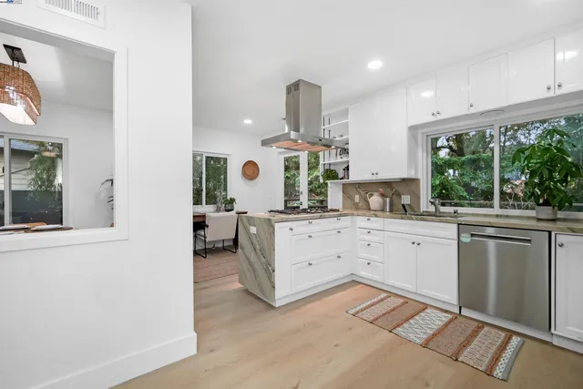 a kitchen with a stove and white cabinets