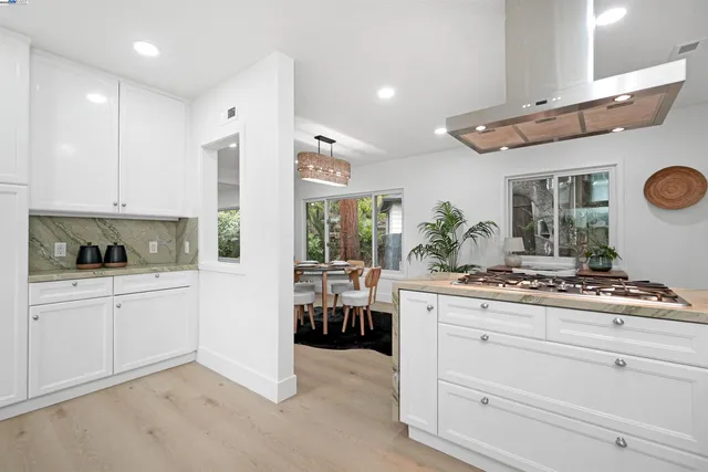 a kitchen with granite countertop white cabinets stainless steel appliances and sink