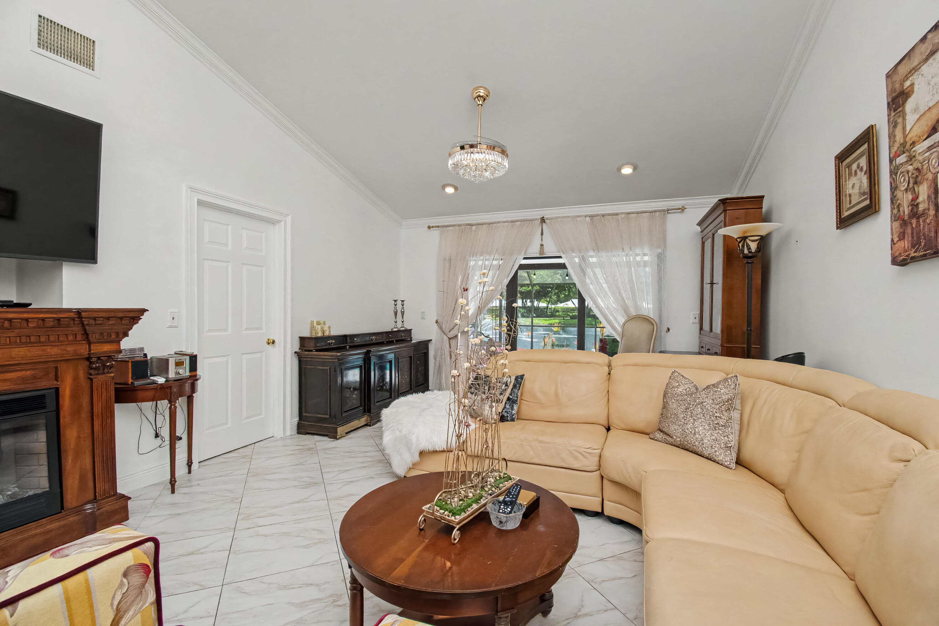9708 Erica Court Boca Raton, FL 33496 - Photo 12 of 54 a living room with furniture a flat screen tv and a fireplace