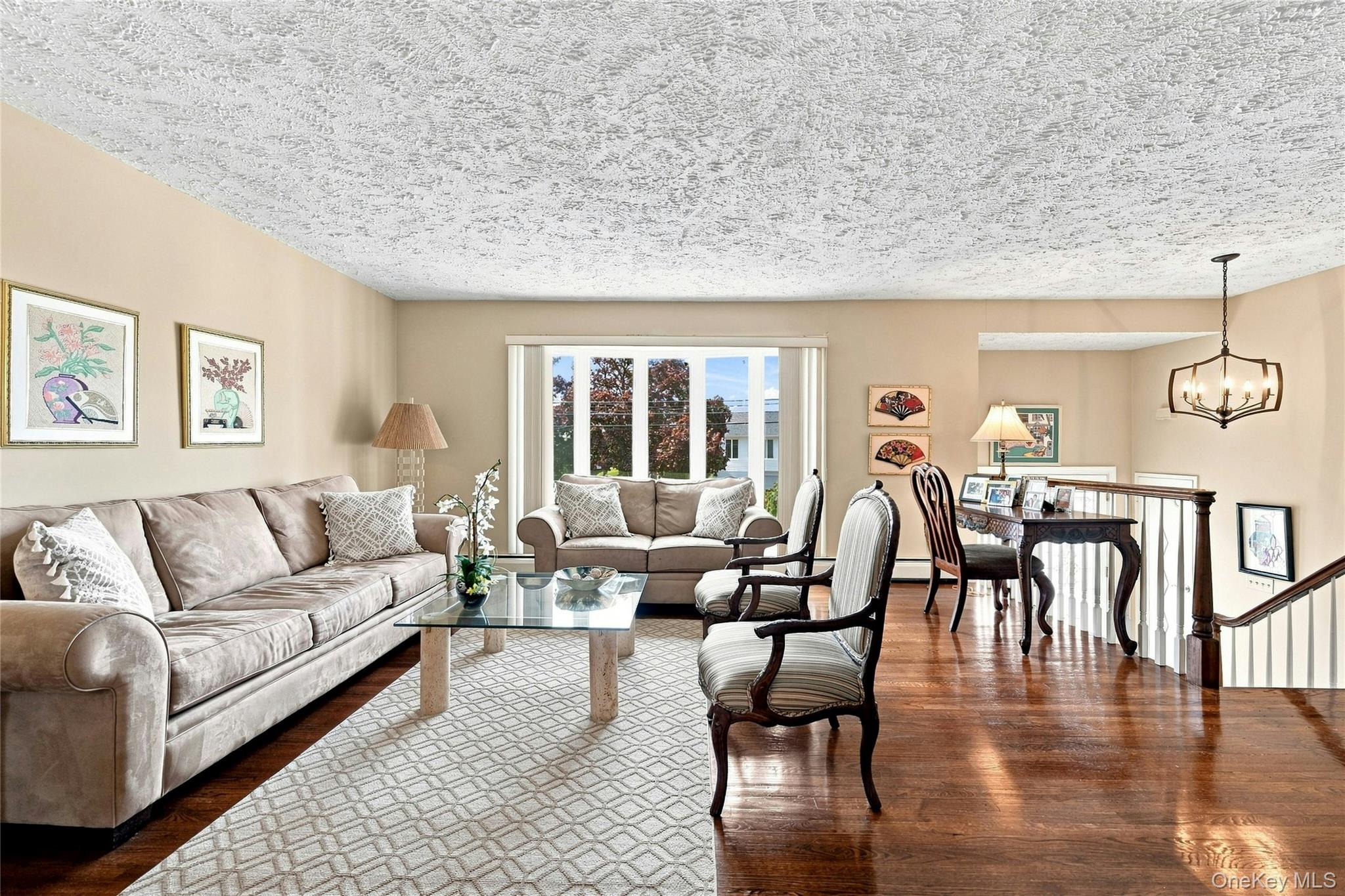3165 Clubhouse Road Merrick, NY 11566 - Photo 10 of 45 Expansive living room featuring rich hardwood flooring, and a bow window bringing ample natural light to the space