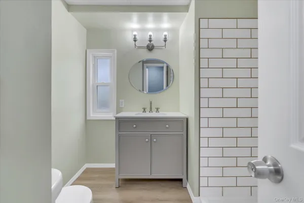a bathroom with a sink a toilet and mirror