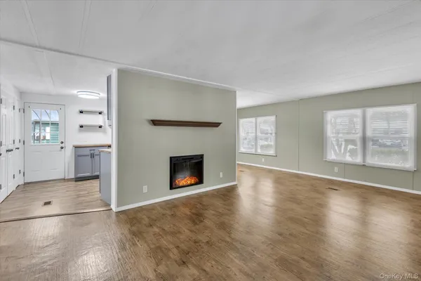 an empty room with windows and fireplace