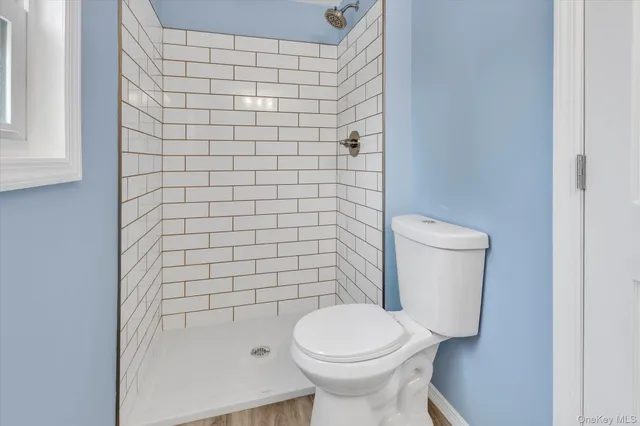 a white toilet sitting next to a shower