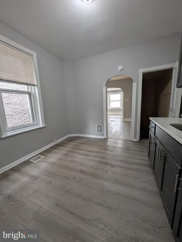 a view of empty room with window and wooden floor