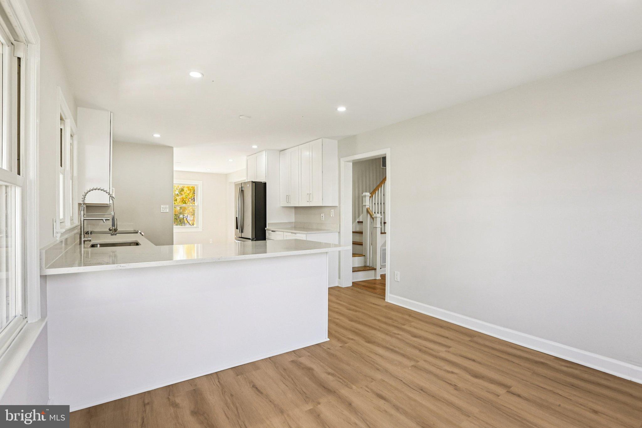 10571 Scaggsville Road Laurel, MD 20723 - Photo 13 of 60 a large kitchen with stainless steel appliances a large counter top a sink and a refrigerator