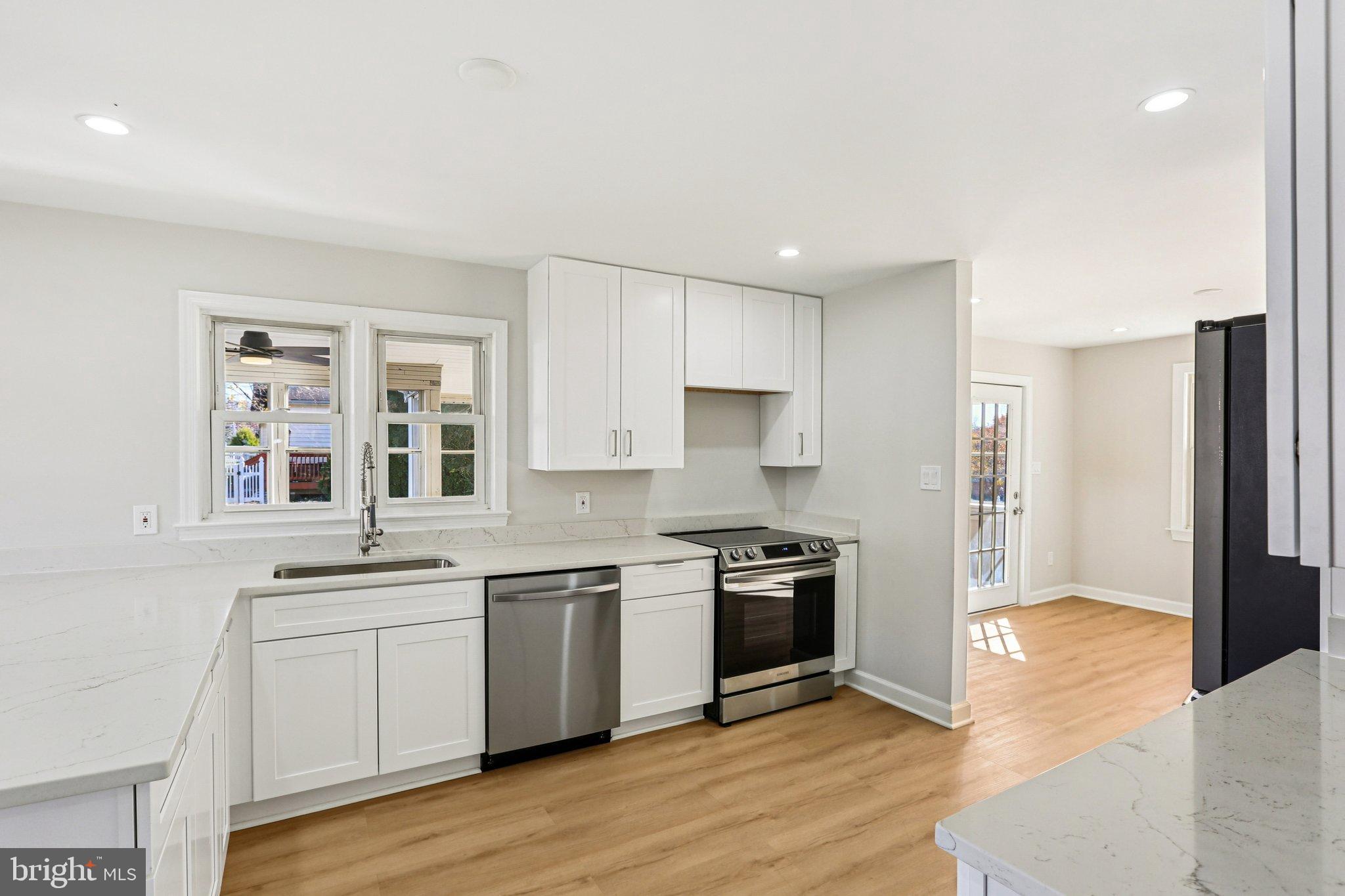 10571 Scaggsville Road Laurel, MD 20723 - Photo 15 of 60 a kitchen with stainless steel appliances granite countertop a stove top oven a sink and a refrigerator