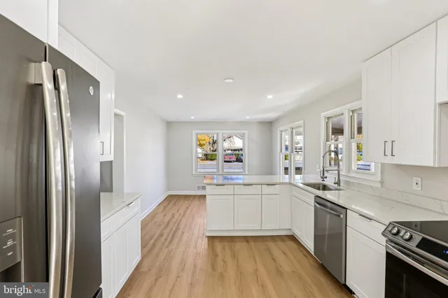 a view of a kitchen with refrigerator and wooden floor