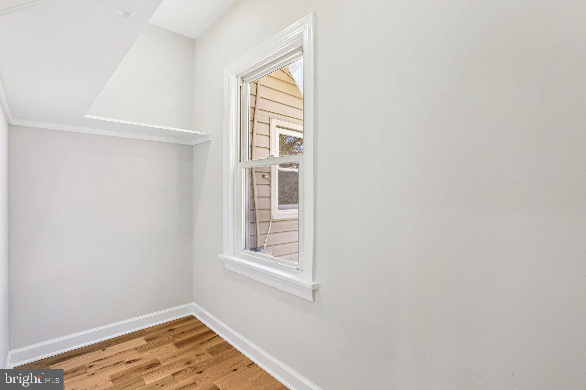 10571 Scaggsville Road Laurel, MD 20723 - Photo 33 of 60 a view of an empty room with wooden floor and a window