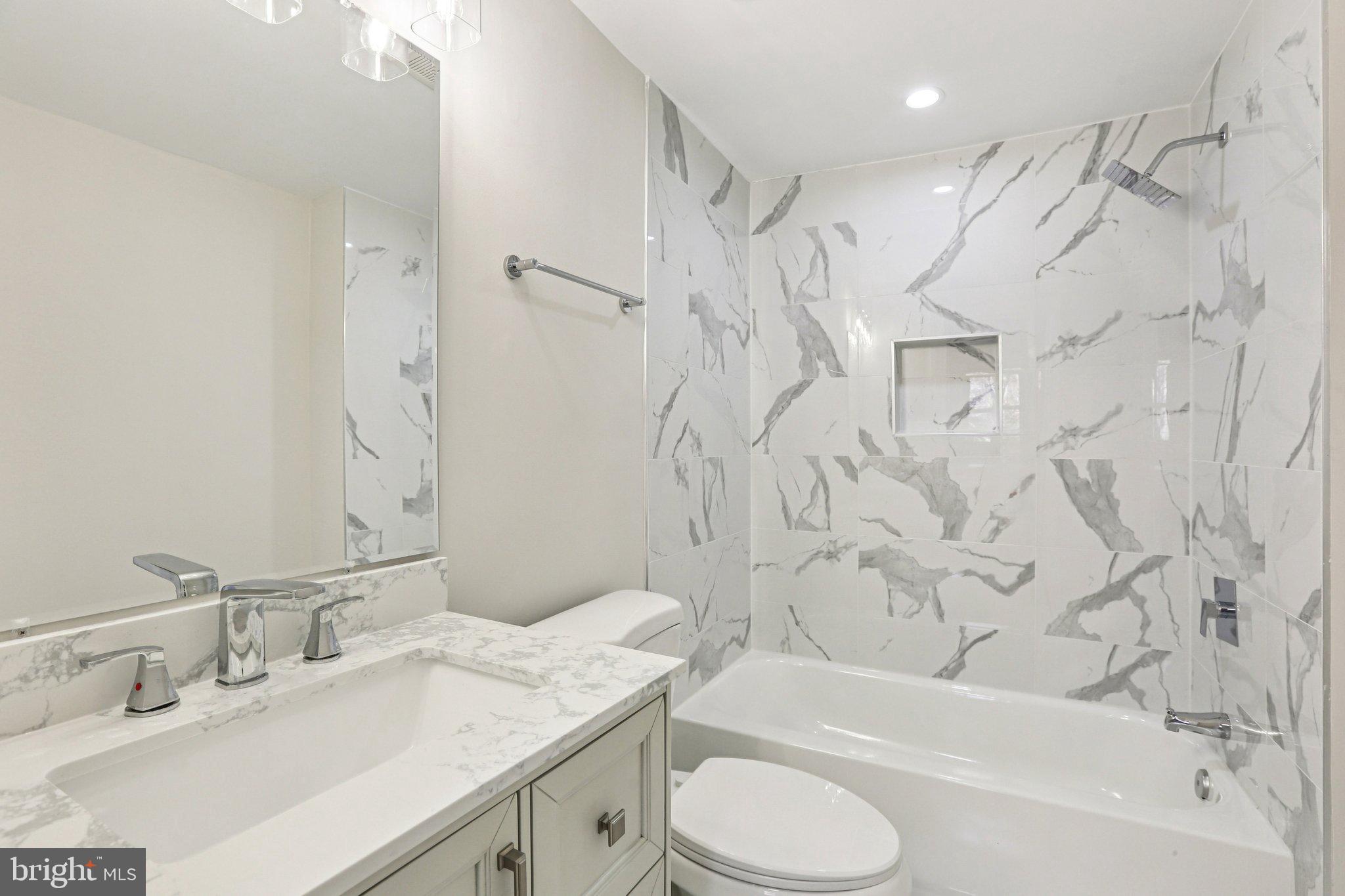 10571 Scaggsville Road Laurel, MD 20723 - Photo 35 of 60 a bathroom with a granite countertop sink toilet and shower
