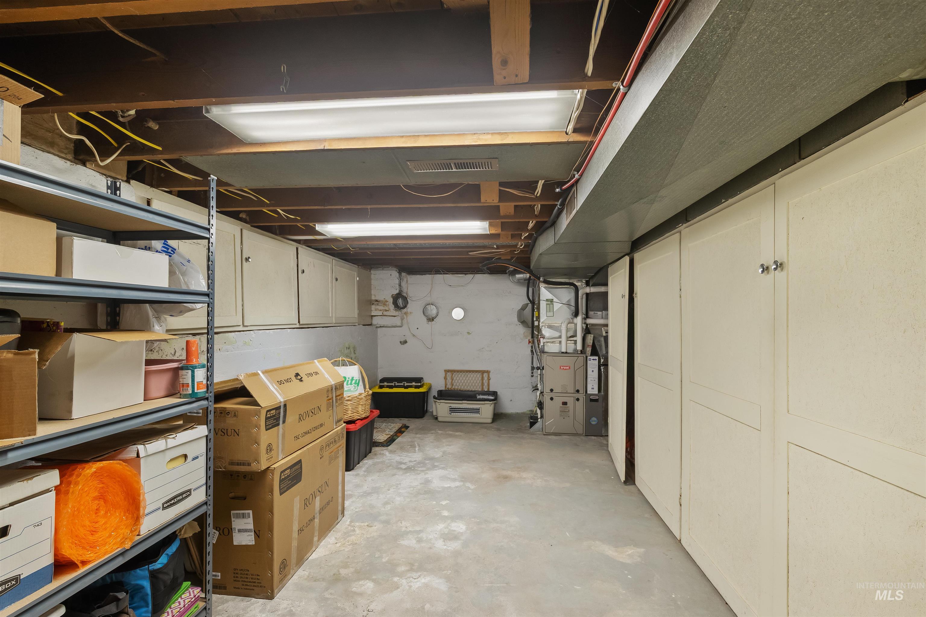 924 N Street Lewiston, ID 83501 - Photo 31 of 46 Utility space featuring exposed ceiling joists, overhead fluorescent lighting, and a concrete floor