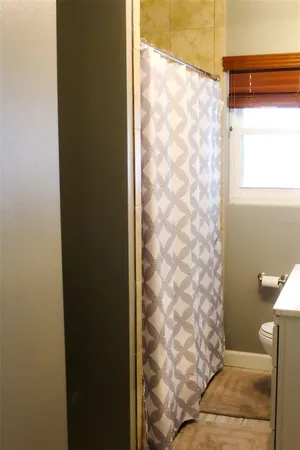 a bathroom with a shower curtain and a toilet