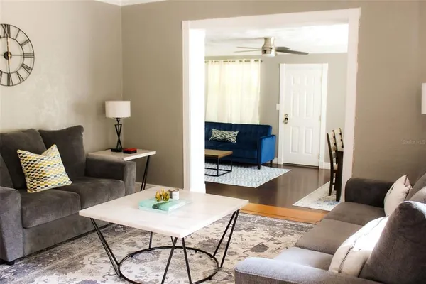 a living room with furniture a flat screen tv and a window