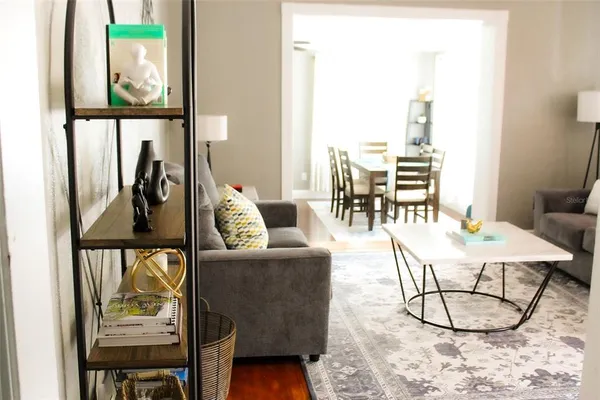 a living room with furniture and a painting on the wall