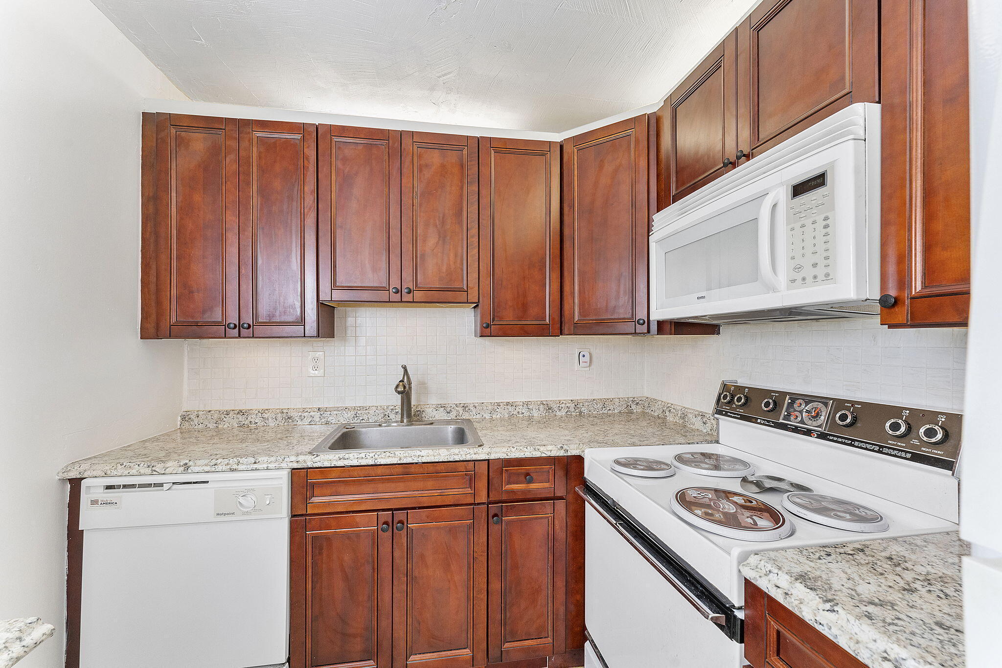 877 Flanders South Delray Beach, FL 33484 - Photo 16 of 27 a kitchen with stainless steel appliances granite countertop a sink stove and cabinets