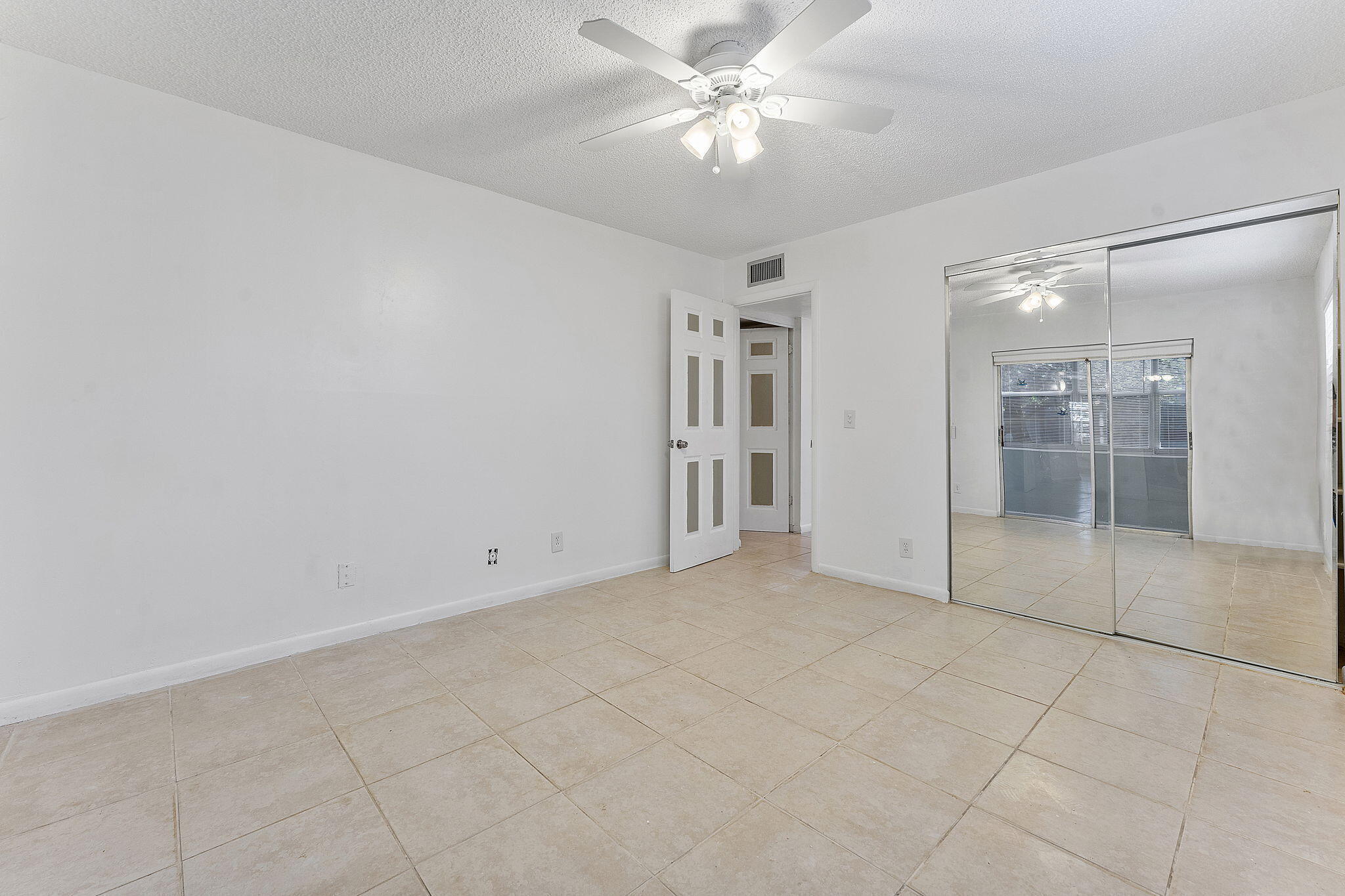877 Flanders South Delray Beach, FL 33484 - Photo 21 of 27 an empty room with a ceiling fan and glass door