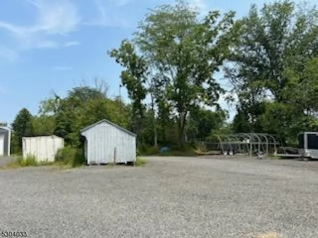 a view of backyard with table and chairs and wooden fence