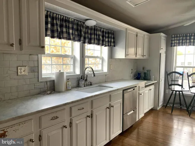 a kitchen with sink cabinets and wooden floor