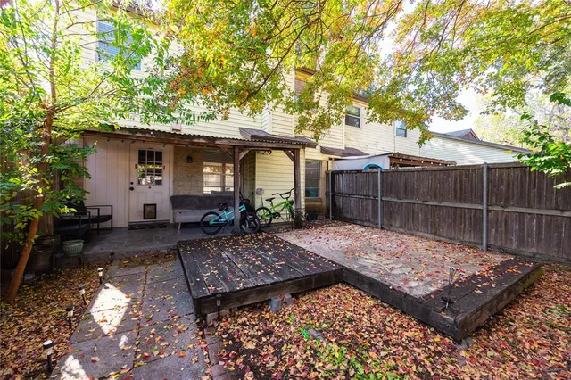 a view of a backyard with a large tree and wooden fence