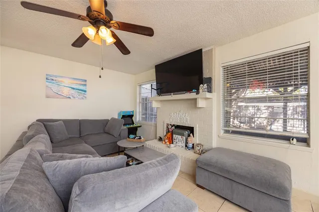 a living room with furniture a flat screen tv and a fireplace