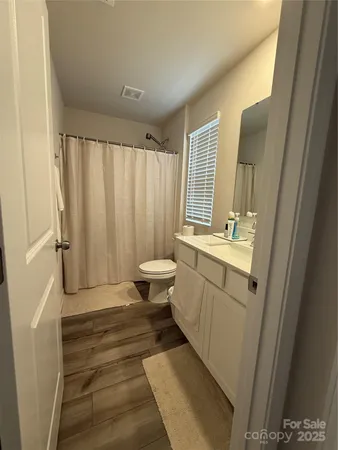 a bathroom with a sink a toilet a mirror and shower