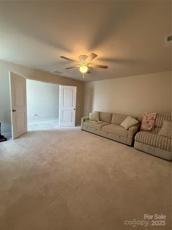 a living room with furniture and a ceiling fan