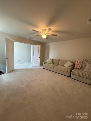 a living room with furniture and a ceiling fan