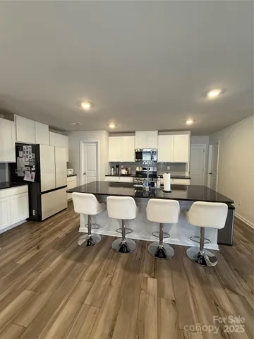 a kitchen with a sink dining table and chairs