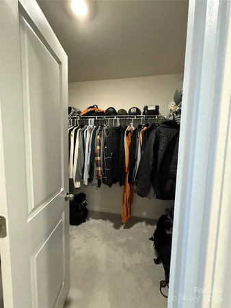 a view of walk in closet with clothes and shoes