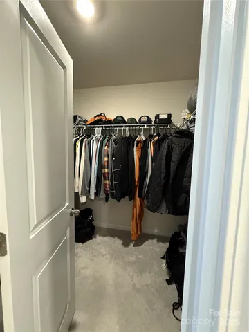 a view of walk in closet with clothes and shoes
