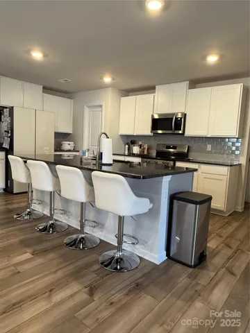 a kitchen with kitchen island granite countertop a sink counter top space appliances and cabinets