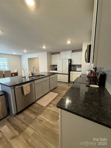 a kitchen with stainless steel appliances granite countertop a sink counter space and cabinets