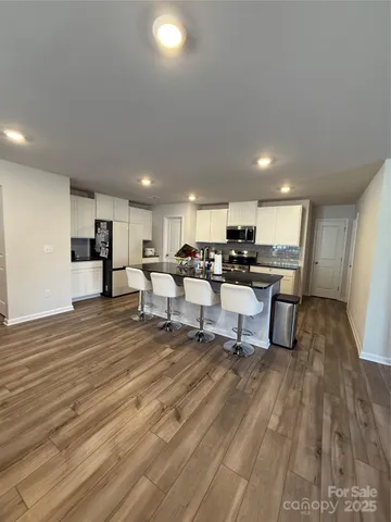 a view of a kitchen with dining room and wooden floor