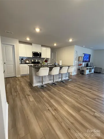 a living room with furniture and kitchen view